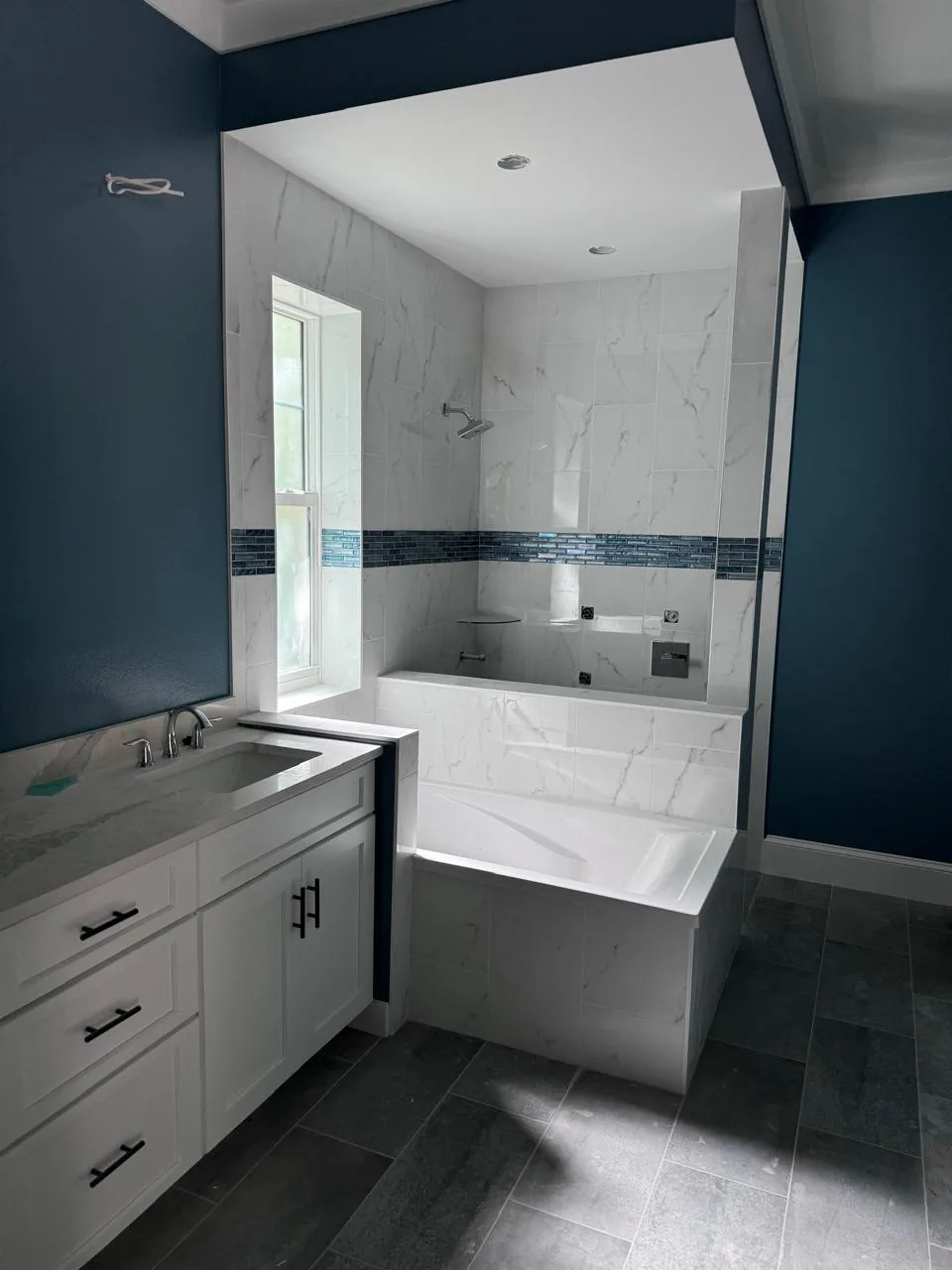 Bathroom vanity beside a tiled shower and tub