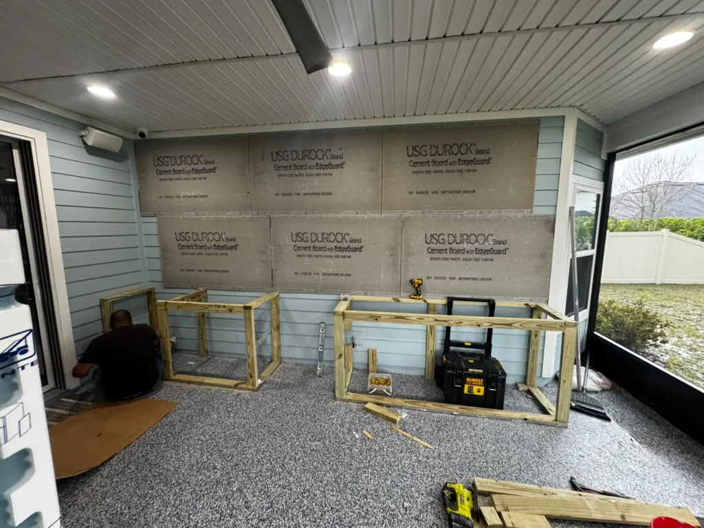 The covered patio before installation, with exposed wall and kitchen framing